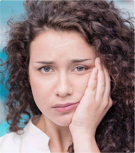 woman holding her jaw in pain