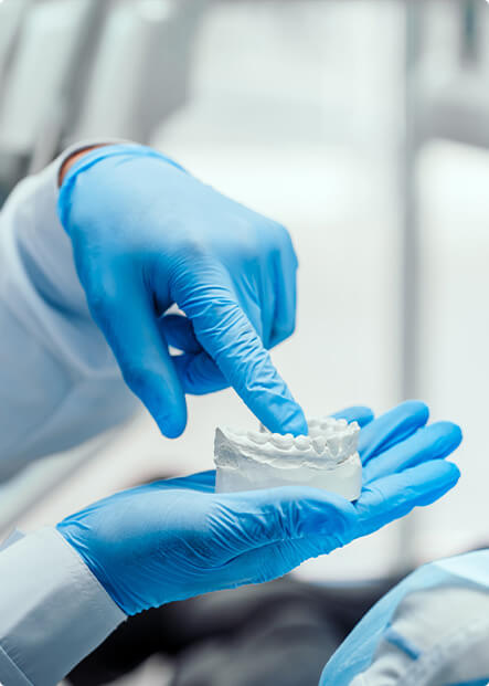 dentist pointing to a model of teeth