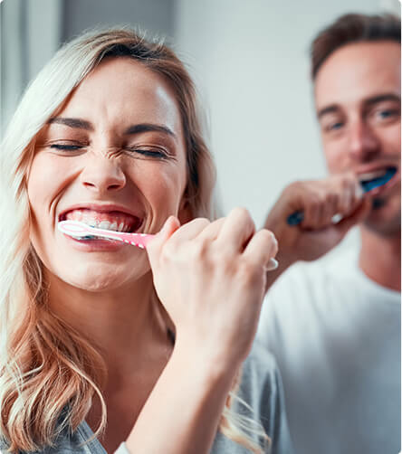 young couple brushing their teeth together