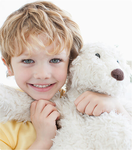 young boy playing with his teddy bear