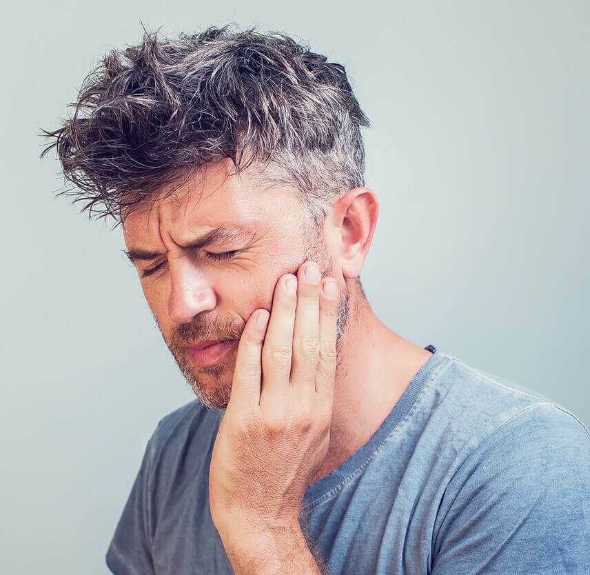 man holding his jaw in pain