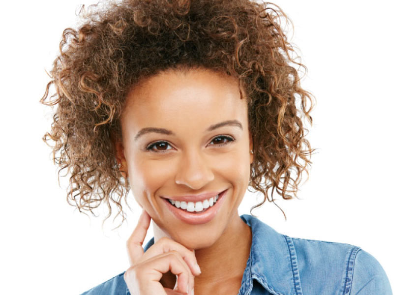 Pretty smiling woman with dark curly hair and beautiful teeth.