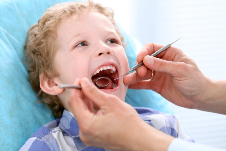 young boy gets a dental exam and cleaning before going back to school